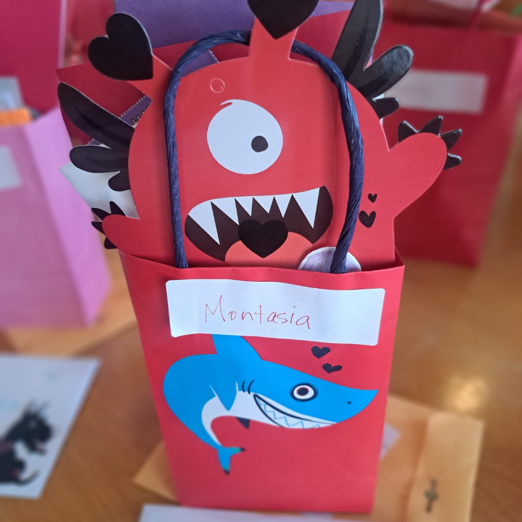 Images of a valentine treat bag stuffed with volunteers' love notes, and featuring an adorable "monster"